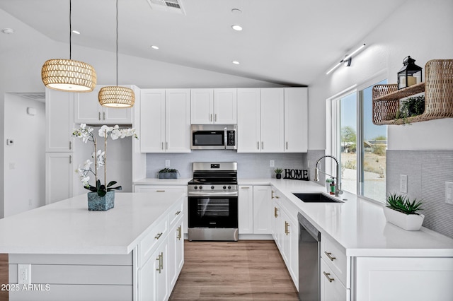 11509 W Langford Ct, Youngtown, AZ 85363 - kitchen with appliances with stainless steel finishes, a sink, lofted ceiling, backsplash, and white cabinetry