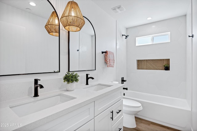 11509 W Langford Ct, Youngtown, AZ 85363 - bathroom featuring double vanity, toilet, shower / tub combination, wood finished floors, and recessed lighting