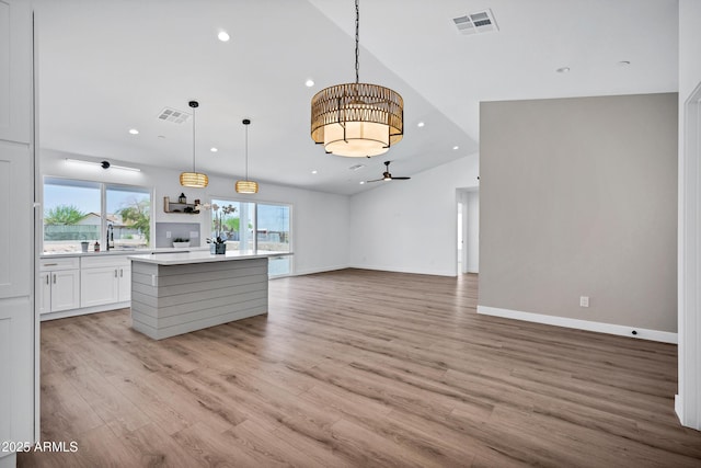 11509 W Langford Ct, Youngtown, AZ 85363 - kitchen featuring open floor plan, light countertops, recessed lighting, light wood finished floors, and white cabinets