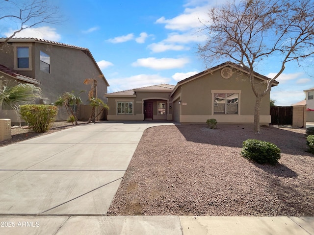 view of front facade featuring concrete driveway, a tiled roof, and stucco siding