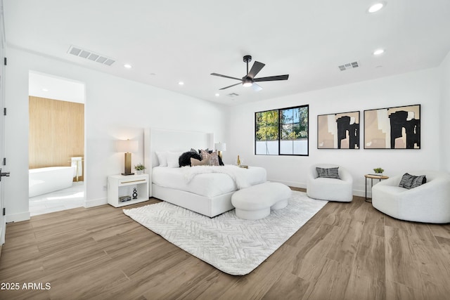 bedroom featuring ensuite bath, light hardwood / wood-style floors, and ceiling fan