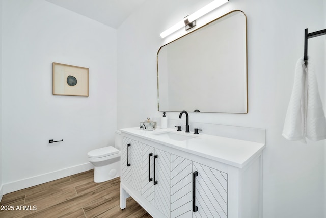 bathroom with hardwood / wood-style flooring, vanity, and toilet