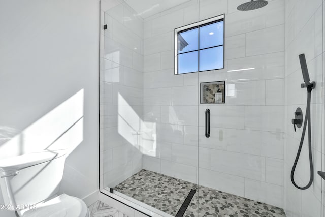 bathroom featuring a shower with shower door and toilet