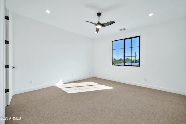 spare room with light colored carpet and ceiling fan