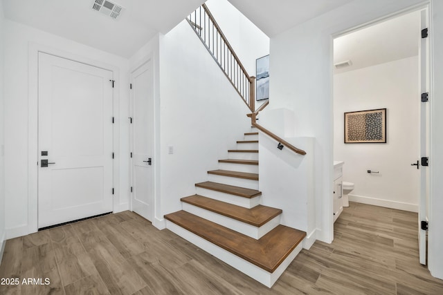 stairs featuring hardwood / wood-style floors