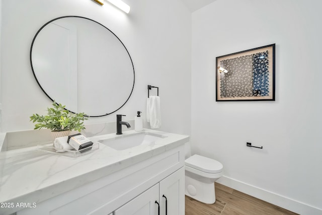 bathroom with vanity, toilet, and hardwood / wood-style floors