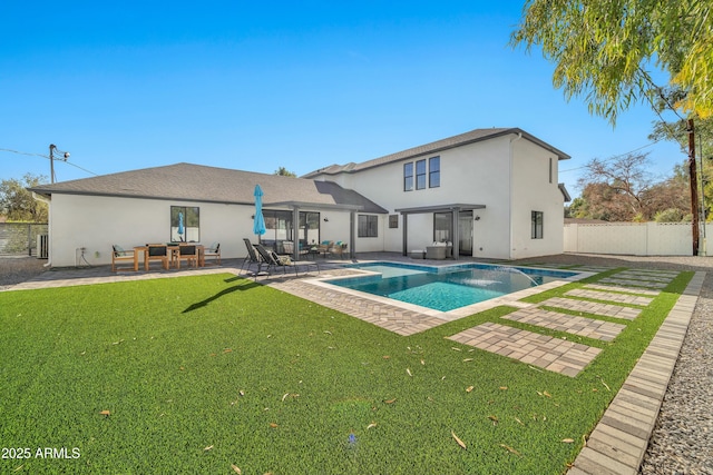 back of property featuring a fenced in pool, a patio, and a lawn