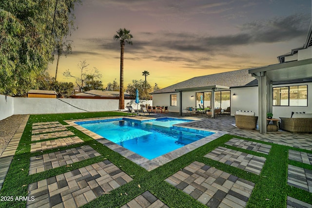 pool at dusk with a patio