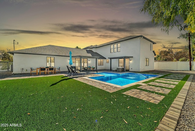 pool at dusk featuring a yard and a patio area