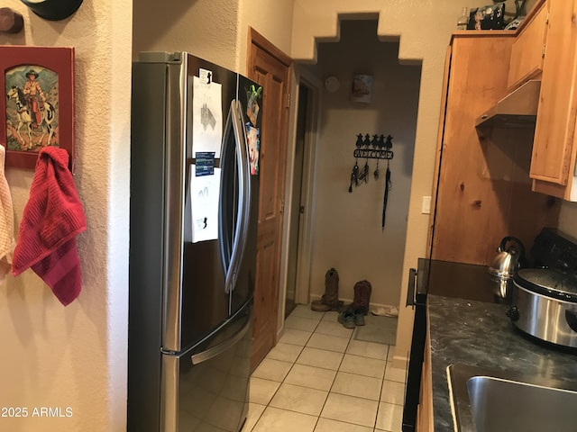 39281 Ave 61 Unit 1/2, Salome, AZ 85348 - kitchen featuring stainless steel fridge, under cabinet range hood, light tile patterned floors, a textured wall, and dark countertops