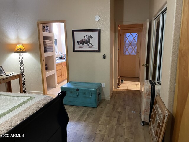 39281 Ave 61 Unit 1/2, Salome, AZ 85348 - bedroom featuring wood finished floors, baseboards, a textured wall, and connected bathroom