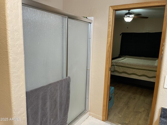 39281 Ave 61 Unit 1/2, Salome, AZ 85348 - bathroom featuring connected bathroom, wood finished floors, a shower stall, ceiling fan, and a textured wall