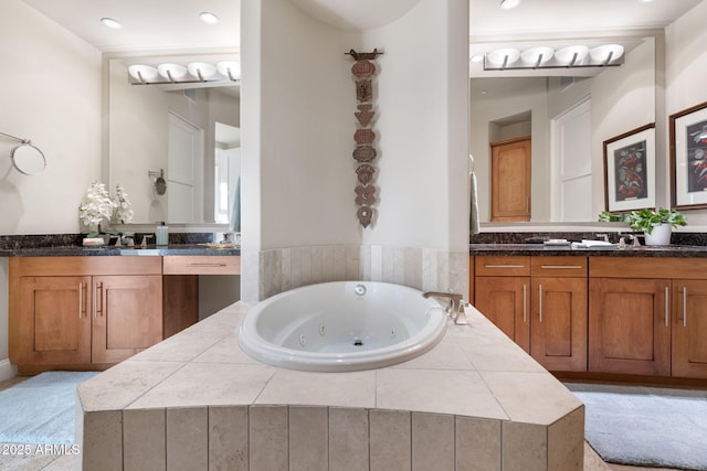 bathroom featuring tiled bath and vanity