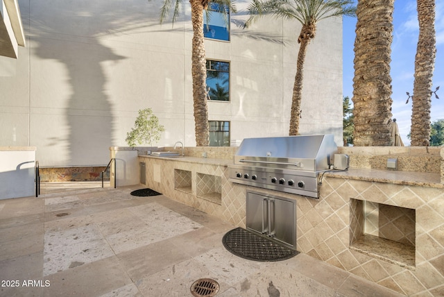 view of patio with exterior kitchen, sink, and area for grilling