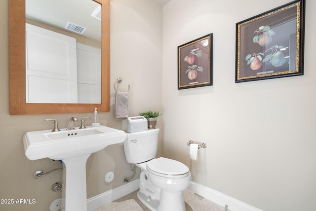 bathroom featuring sink, toilet, and tile patterned flooring