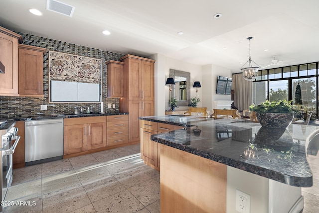 kitchen featuring ceiling fan with notable chandelier, pendant lighting, a large island, and stainless steel appliances