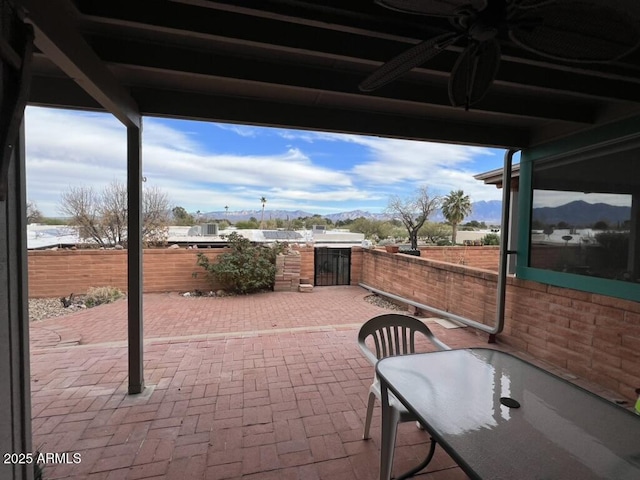 view of patio with a mountain view, ceiling fan, and a fenced backyard