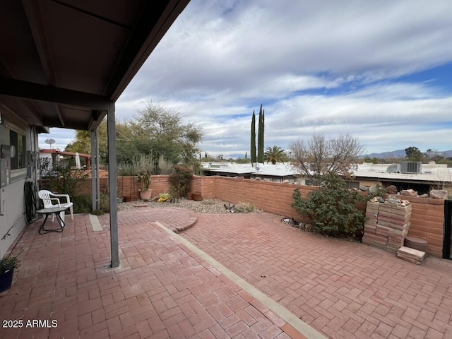 view of patio / terrace featuring fence, central AC, and a mountain view