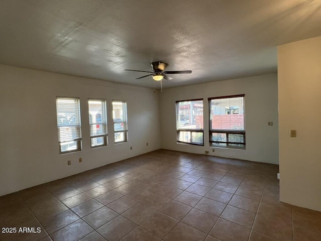 unfurnished room with a ceiling fan and tile patterned flooring