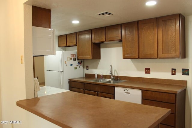 kitchen featuring visible vents, recessed lighting, white appliances, and a sink