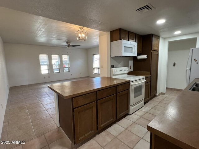 kitchen with ceiling fan with notable chandelier, visible vents, light tile patterned floors, and white appliances