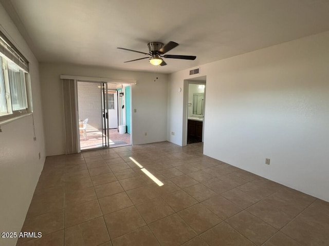 spare room with tile patterned flooring, a ceiling fan, and visible vents