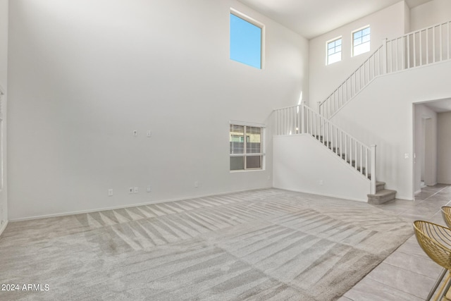 carpeted living room with a towering ceiling