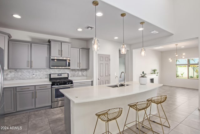 kitchen with appliances with stainless steel finishes, gray cabinets, and sink