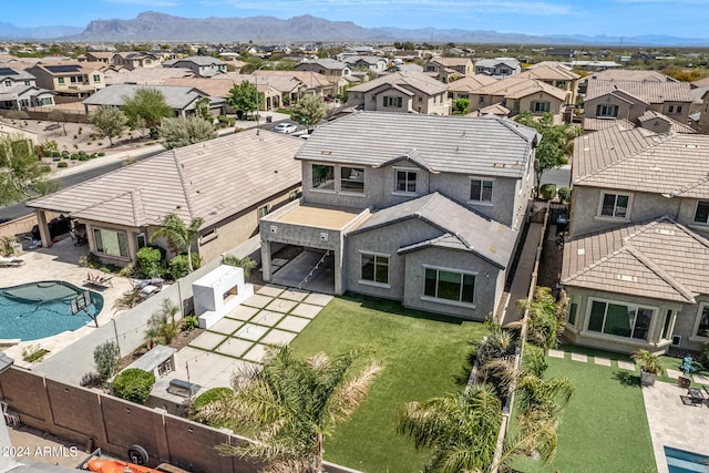 exterior space featuring a patio, a fenced in pool, a mountain view, and a lawn