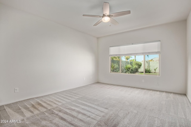 spare room with ceiling fan and light colored carpet