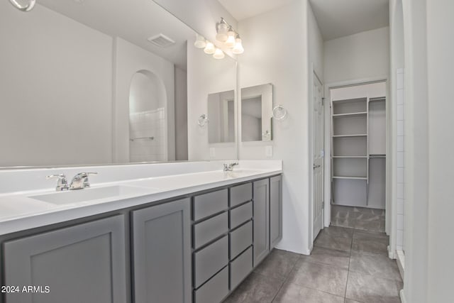 bathroom featuring double sink, oversized vanity, and tile flooring