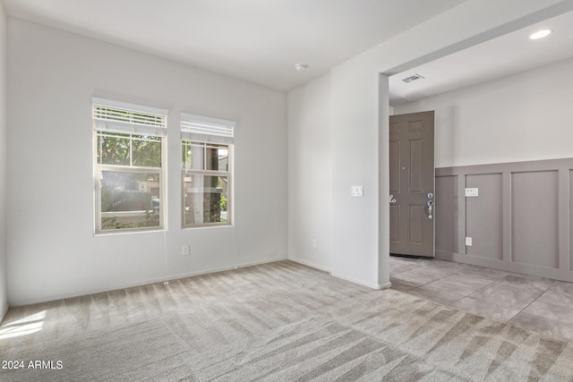 unfurnished room featuring light colored carpet