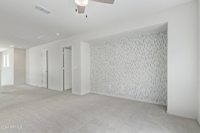 spare room with ceiling fan and light colored carpet