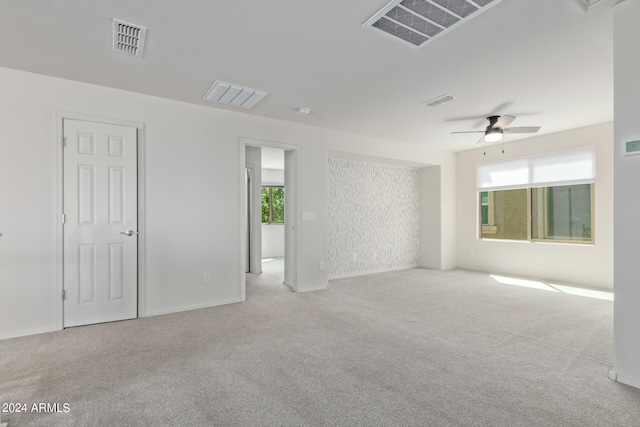 unfurnished room with light colored carpet and ceiling fan