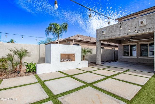 view of terrace featuring an outdoor fireplace and ceiling fan