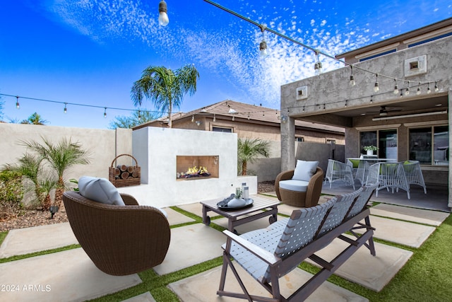 view of patio featuring ceiling fan and an outdoor living space with a fireplace