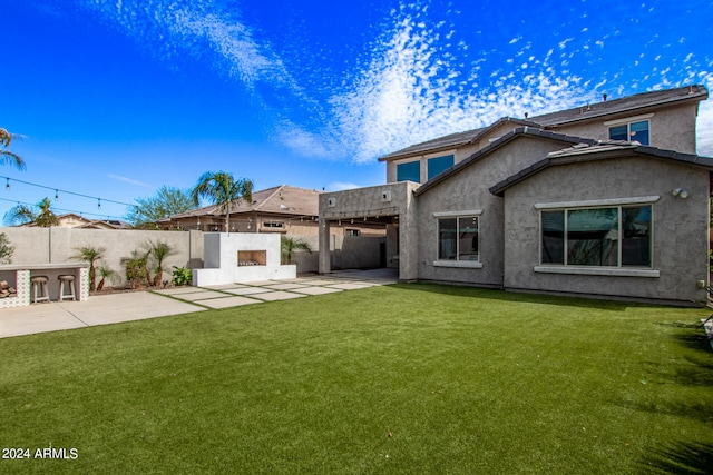 back of house with a patio and a yard