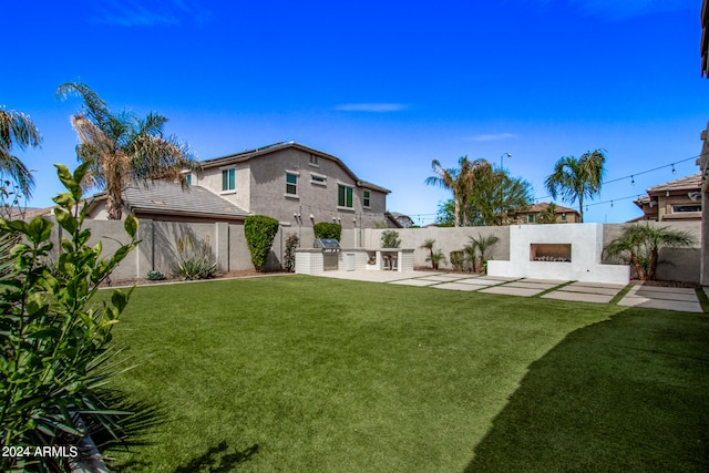 rear view of house with a lawn and a patio area