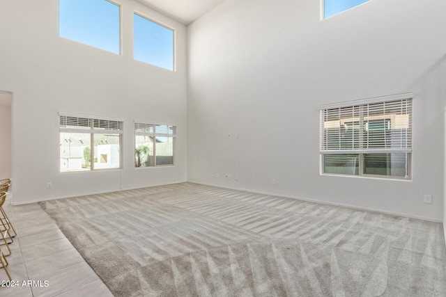 carpeted empty room with a high ceiling