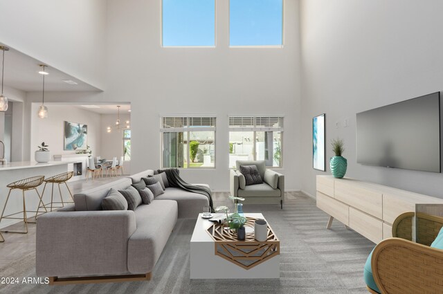 living room with an inviting chandelier, a high ceiling, and plenty of natural light