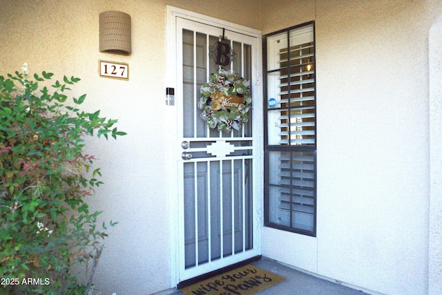 property entrance with stucco siding