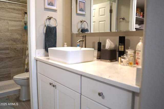 bathroom with vanity, a shower stall, and toilet