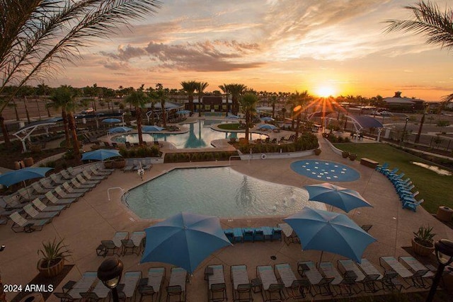 pool at dusk featuring a patio area