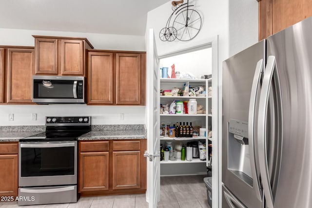 kitchen featuring decorative light fixtures, stone countertops, and stainless steel appliances