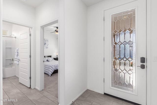 foyer entrance with ceiling fan, light tile patterned floors, and a healthy amount of sunlight