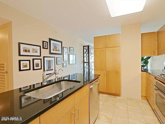 kitchen with stainless steel appliances, a sink, and light tile patterned floors