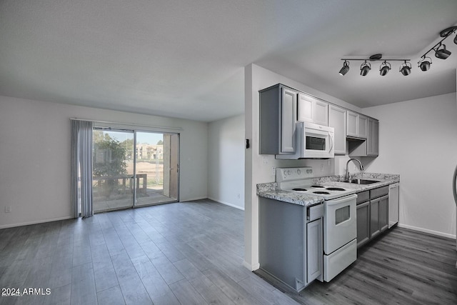 kitchen with white appliances, a textured ceiling, sink, hardwood / wood-style floors, and gray cabinets