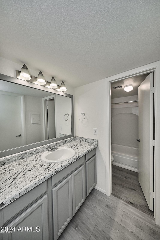 bathroom featuring vanity, a textured ceiling, and hardwood / wood-style flooring