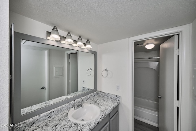 bathroom featuring vanity, wood-type flooring, and a textured ceiling