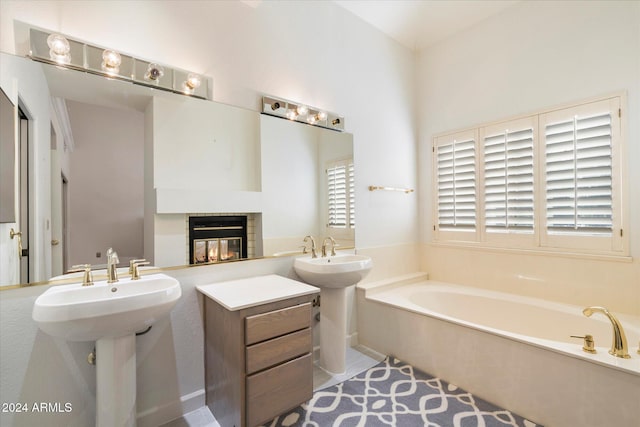 bathroom with tile patterned flooring, double sink, and a tub to relax in